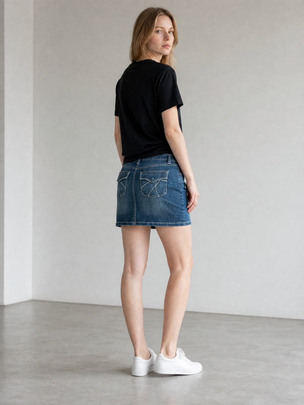 New York & Company blue denim Y2K mini skirt with embroidered back pockets and contrast stitching.