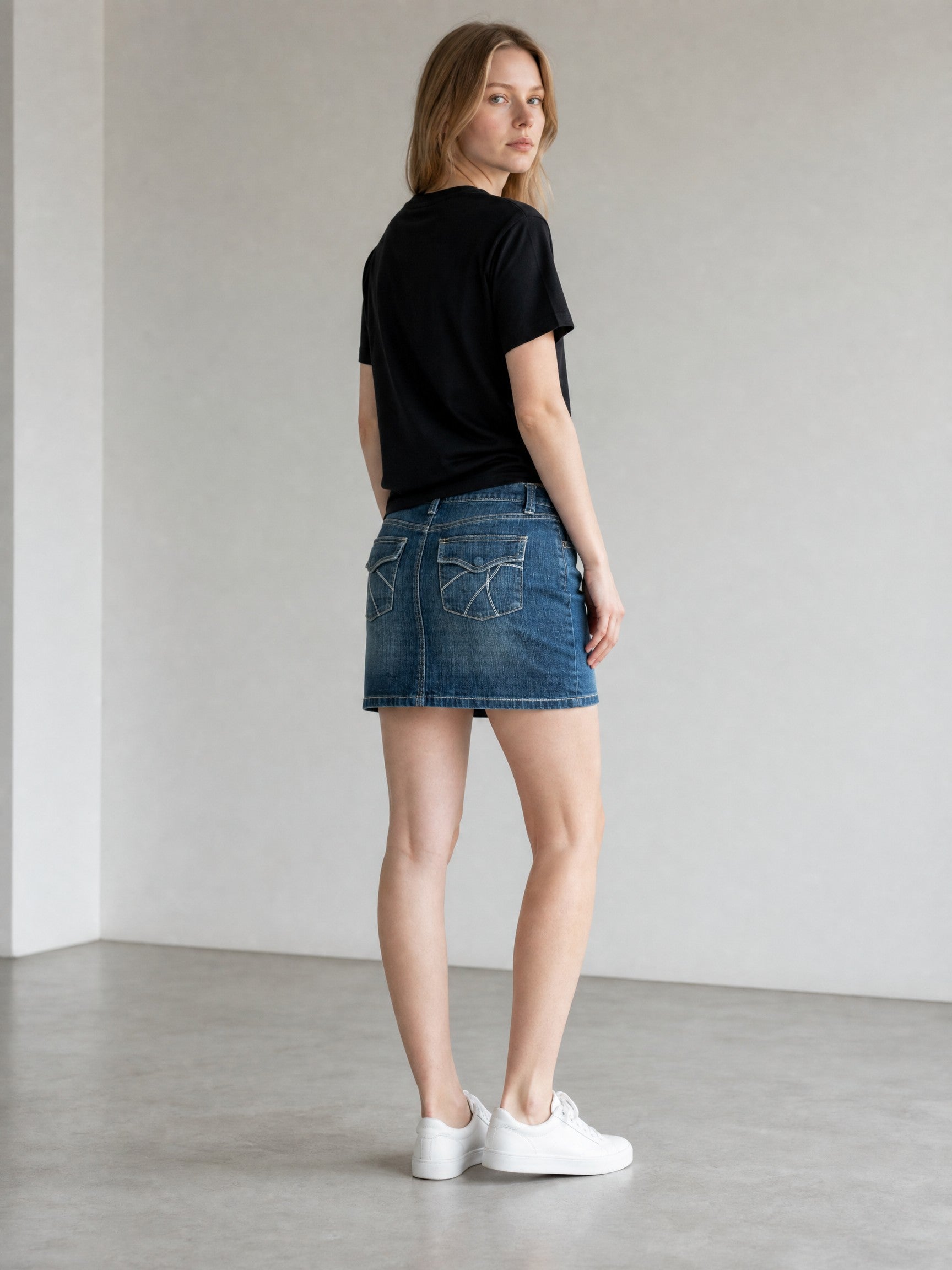 New York & Company blue denim Y2K mini skirt with embroidered back pockets and contrast stitching.