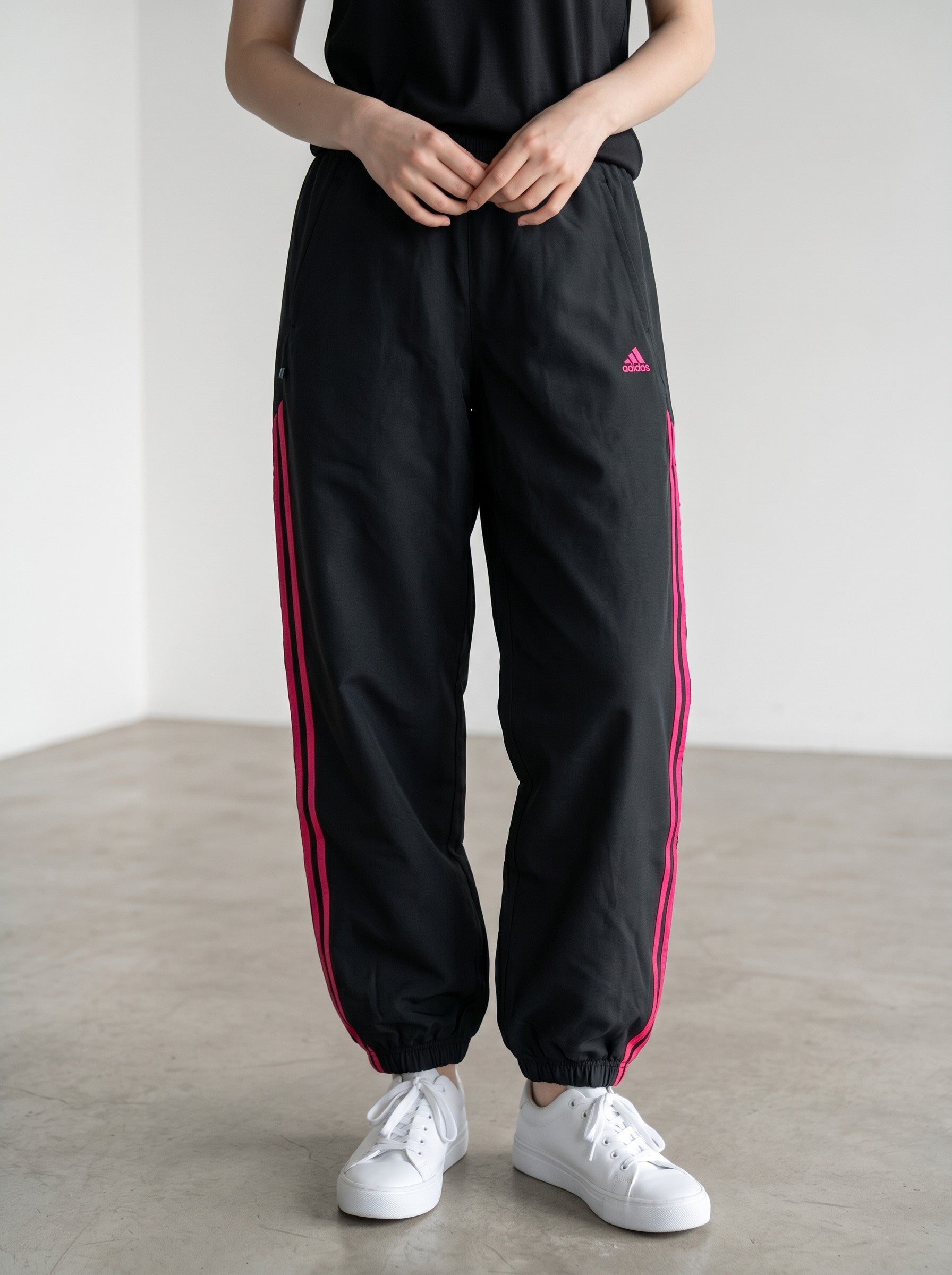 Rewearz black baggy Adidas track pants with pink fuchsia stripes and logo, Y2K style.