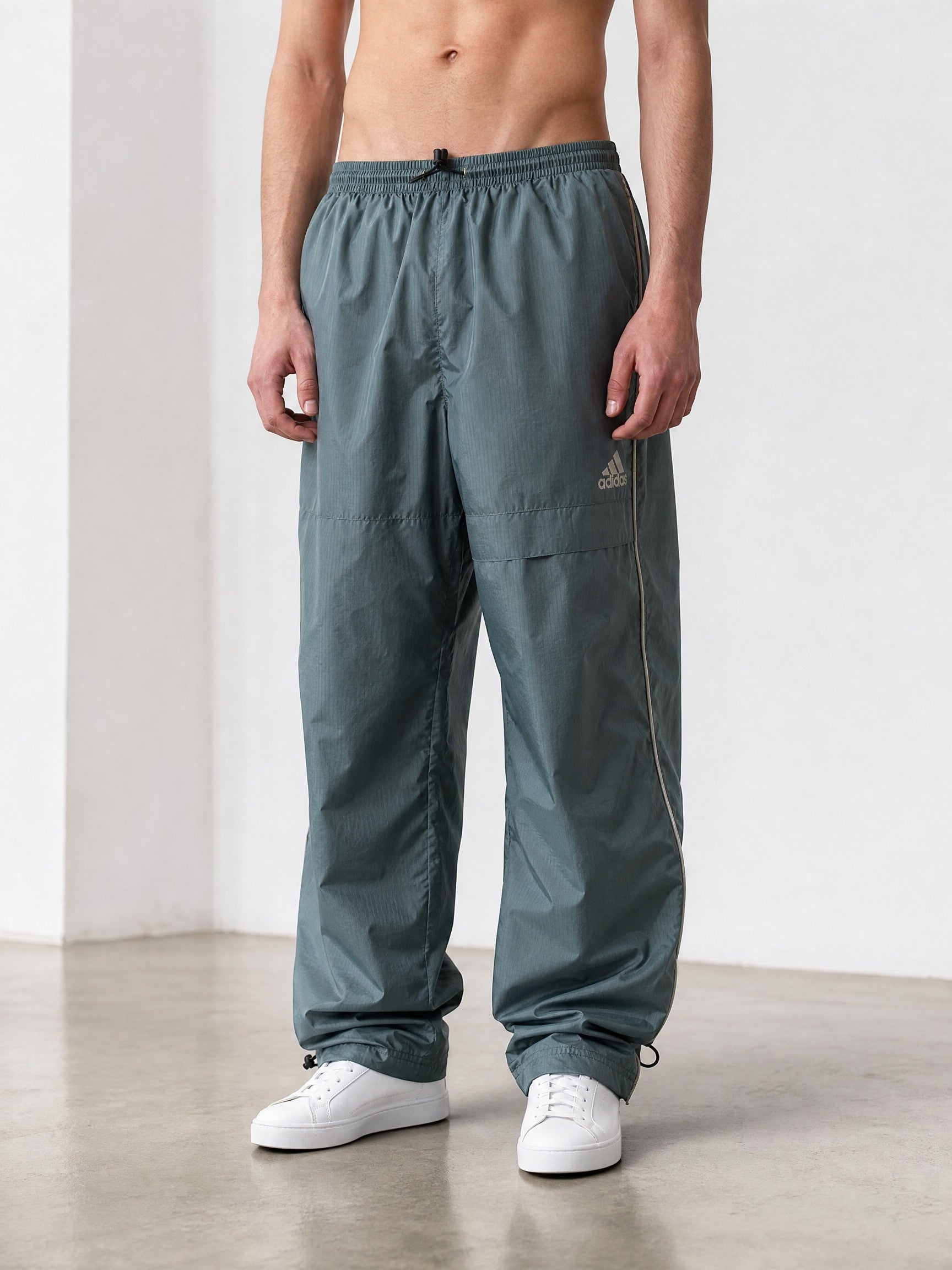 Rewearz vintage grey Adidas parachute cargo pants with reflective side stripes and drawstring ankles.