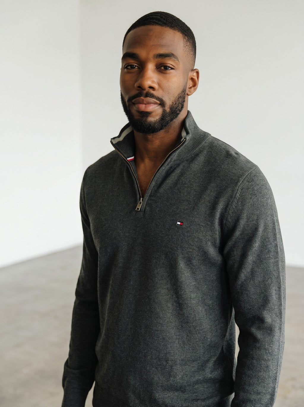 Rewearz dark grey Tommy Hilfiger half-zip sweater with embroidered logo and striped collar detail.