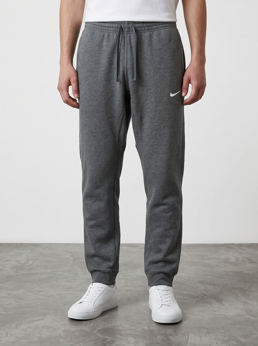 Rewearz grey Nike sweatpants with embroidered white swoosh logo, elastic waistband, and cuffed ankles.