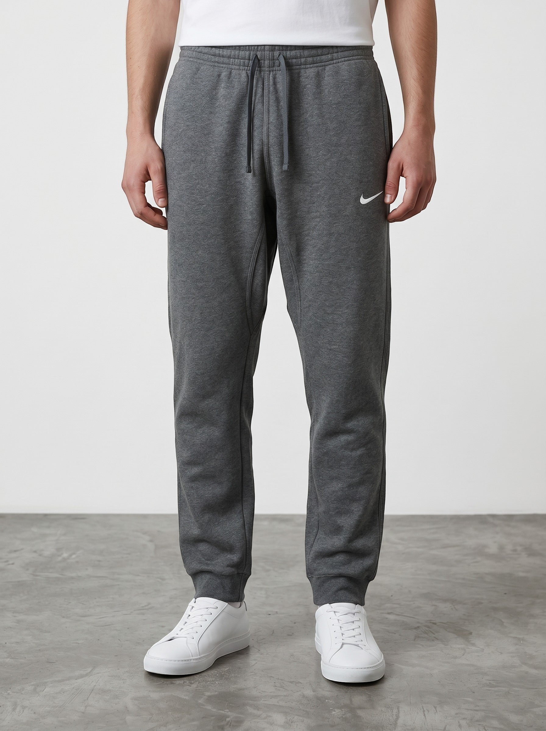 Rewearz grey Nike sweatpants with embroidered white swoosh logo, elastic waistband, and cuffed ankles.