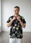 Rewearz black 100% silk Hawaiian shirt with yellow flowers and tropical leaves pattern, short sleeves, relaxed fit.
