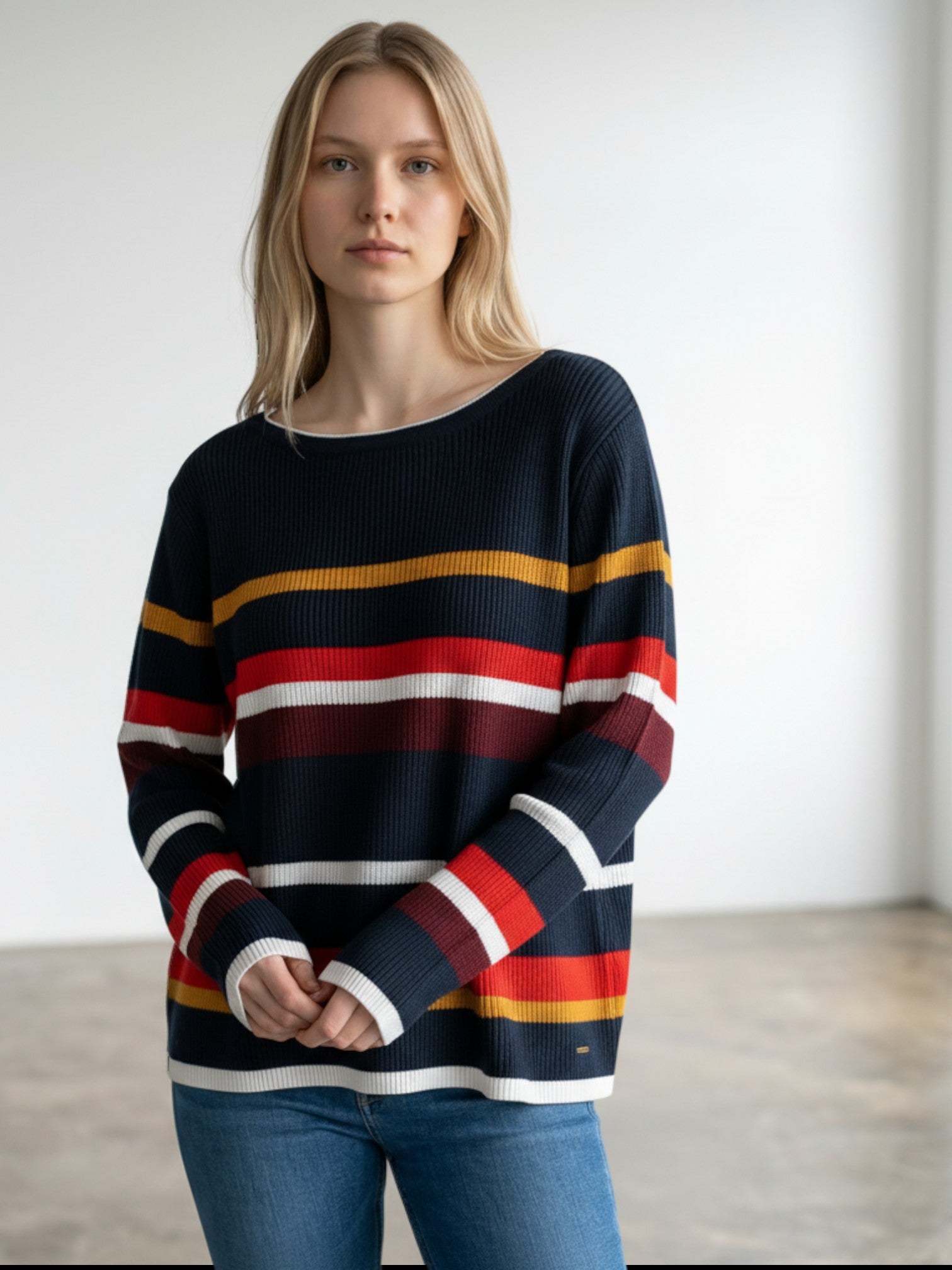 Tommy Hilfiger navy blue oversized sweater with horizontal multicolour stripes in red, yellow, and white.
